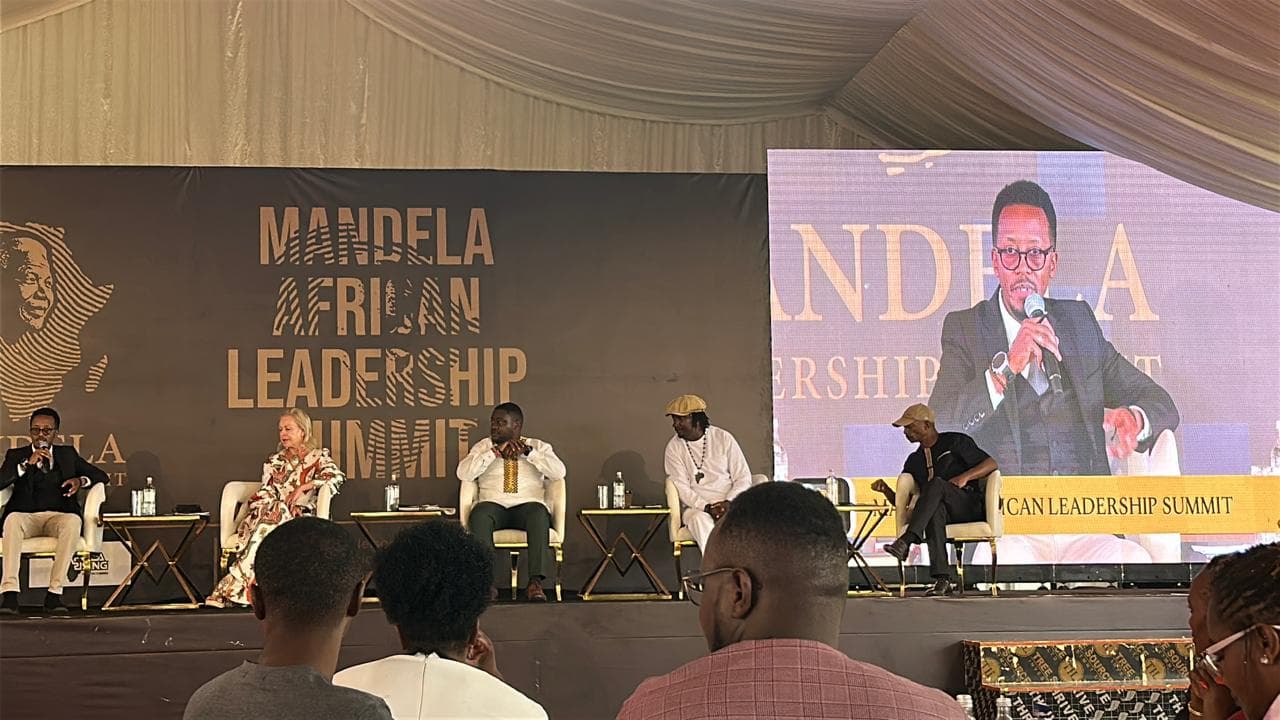 Speakers on stage beside a large screen at the Mandela African Leadership Summit